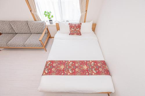 two beds in a room with a couch at Shinjuku Terrace 226 BnB in Tokyo