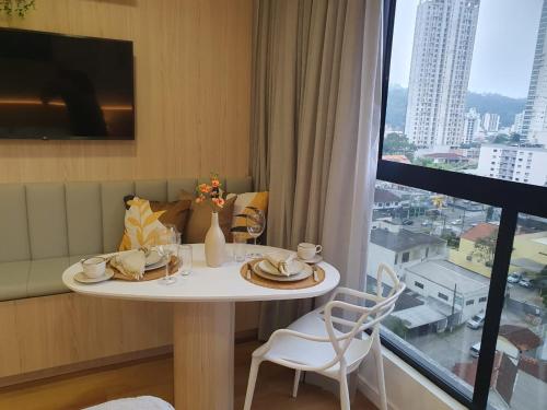 a table in a room with a view of a city at Loft Novo todo Mobiliado com WIFI Piscina e próximo a Oktober in Blumenau