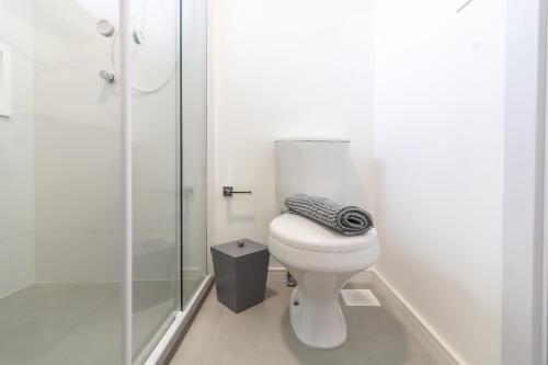 a bathroom with a toilet and a glass shower at Loft Novo todo Mobiliado com WIFI Piscina e próximo a Oktober in Blumenau