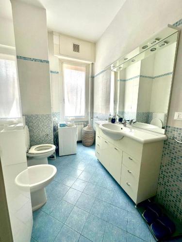 a bathroom with two sinks and a toilet and a mirror at La casa del mare in Marina dʼAndora
