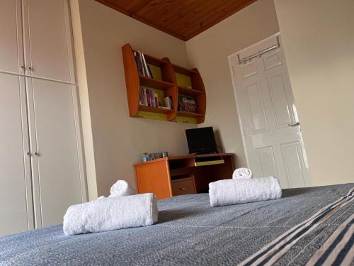 a bedroom with a bed with two pillows on it at Villa V in Artemida