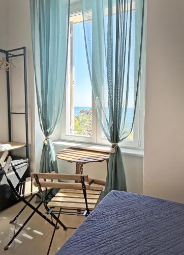 a bedroom with a window with a table and a chair at Hotel Meublè Agavi in Monterosso al Mare