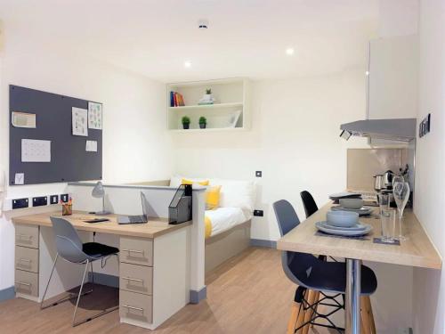 a room with a desk with chairs and a bed at For Students Only at Great Patrick Street in Belfast