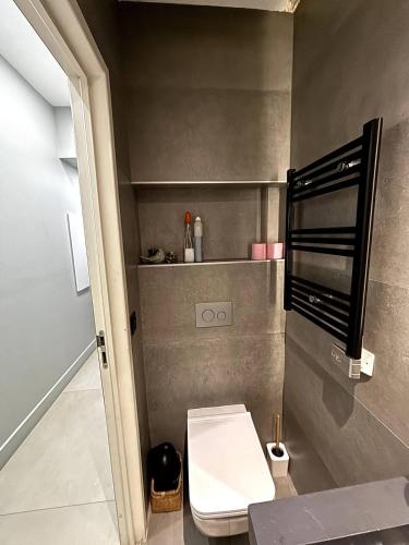 Elle comprend une petite salle de bains pourvue de toilettes et d'une étagère. dans l'établissement Splendide Nice Centre Clim, à Nice