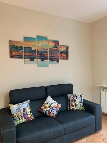 a blue couch in a living room with paintings on the wall at La casa di Barbara in Le Cerquete