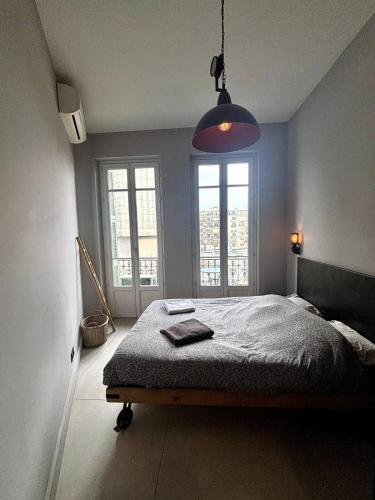 une chambre avec un lit et une grande fenêtre dans l'établissement Splendide Nice Centre Clim, à Nice