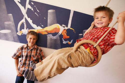 two young boys are playing on a swing at Apartmenthaus SportCHALET in Bad Dürrheim