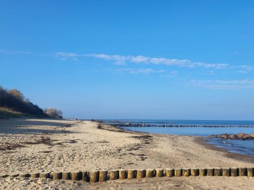 a sandy beach with water and a blue sky at Kleiner Leuchtturm Kühlungsborn in Kühlungsborn
