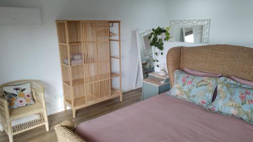 a bedroom with a bed and a chair and a mirror at Quinta Castilho in Fortes de Cima