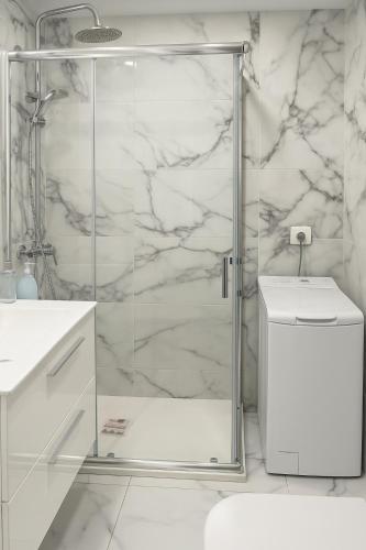 a white bathroom with a shower and a toilet at Residence Los Molinos in Maspalomas
