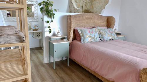 a bedroom with a bed with a wicker headboard at Quinta Castilho in Fortes de Cima
