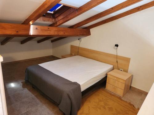 - une petite chambre avec un lit et des plafonds en bois dans l'établissement linguizzetta , les marines de bravone, à Linguizzetta