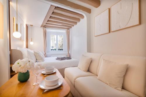 un salon avec un canapé blanc et une table dans l'établissement Louvre - Rivoli - Designer Studio - Sleeps 3P, à Paris