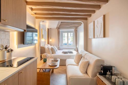 un salon avec un canapé blanc et une table dans l'établissement Louvre - Rivoli - Designer Studio - Sleeps 3P, à Paris