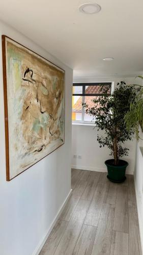 a painting on a wall in a room with a potted plant at Quinta Castilho in Fortes de Cima