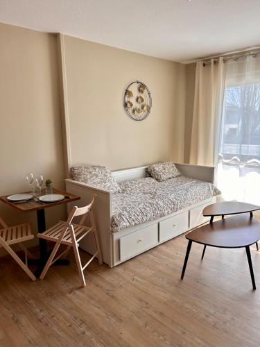 une chambre avec un lit, une table et des chaises dans l'établissement Votre évasion au bord de mer, à Courseulles-sur-Mer