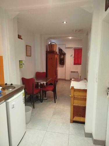 une cuisine et une salle à manger avec une table et des chaises dans l'établissement Meublé Krutenau Strasbourg, à Strasbourg