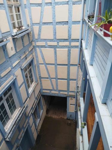 - une vue de tête sur un bâtiment doté de fenêtres bleues et blanches dans l'établissement Meublé Krutenau Strasbourg, à Strasbourg