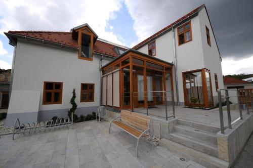 a white house with a bench in front of it at Gizella Hotel and Restaurant in Veszprém