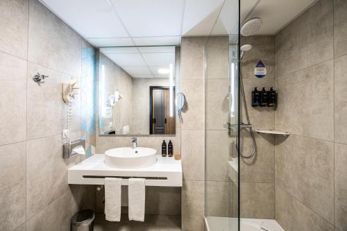 łazienka z umywalką i prysznicem w obiekcie Mercure Wrocław Centrum we Wrocławiu