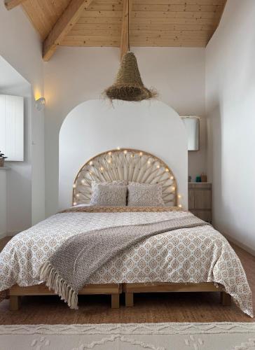 a bedroom with a large bed with a wooden headboard at Casa Pompilio in Sagres