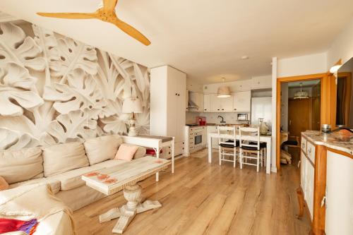 a living room with a couch and a kitchen at encantador apto en la playa in Comarruga
