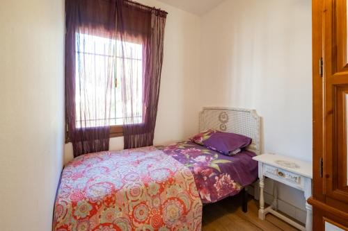 a small bedroom with a bed and a window at encantador apto en la playa in Comarruga