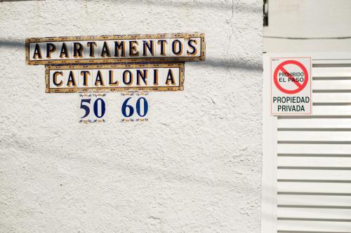 a street sign on a wall with a no parking sign at encantador apto en la playa in Comarruga