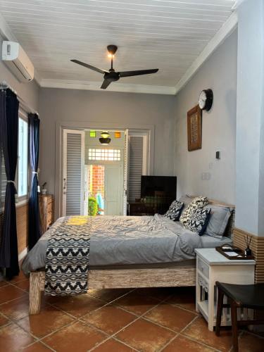a bedroom with a bed and a ceiling fan at villa Angin in Munggu