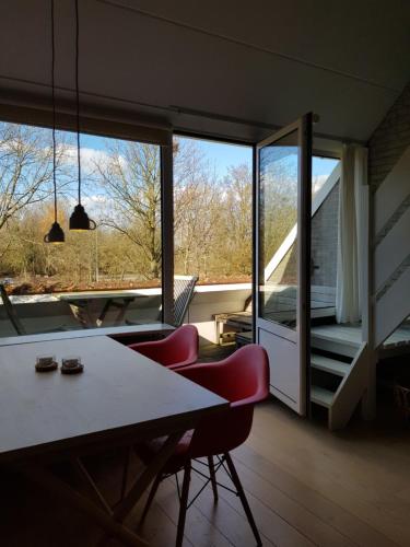a room with a table and chairs and a large window at Zeeland cosy duplex appartment in Summio Parc Aquadelta resort in Bruinisse