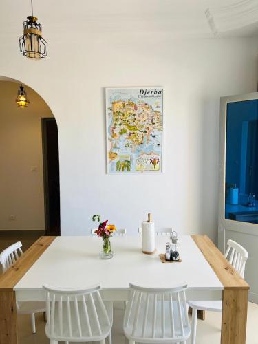 a dining room with a white table and white chairs at Dream Garden Djerba in Djerba