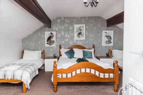 two twin beds in a bedroom with a wall at Denecrest Guest House in Windermere