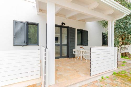 a white house with a pergola and a patio at Le Case di Chri in Mattinata