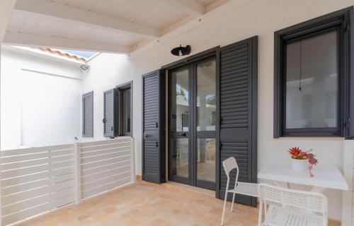 a patio with black doors and a white table and chairs at Le Case di Chri in Mattinata
