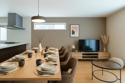 a dining room with a table and chairs and a television at Villa RIKUNOYA SUZUKA in Suzuka