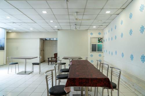 a conference room with tables and chairs and a wall at Hotel Jasmine Paldi Ahmedabad in Ahmedabad