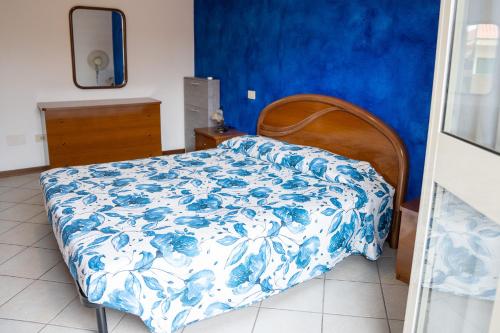 a bedroom with a bed with a blue and white bedspread at La Casa del Sole e della Luna in Càbras