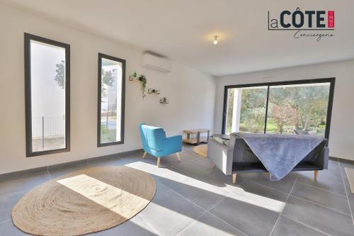 - un salon avec une table et une chaise bleue dans l'établissement Villa Phi, à Ensuès-la-Redonne