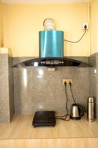 a stove in a kitchen with a pot on the floor at Kathmandu room with great view, like resort in Bālāju