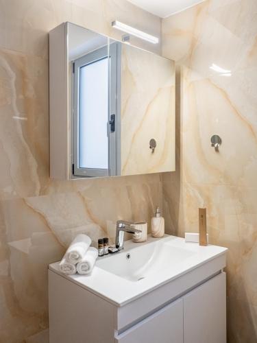 a bathroom with a sink and a mirror at Natalia's Lovely House in Artemida