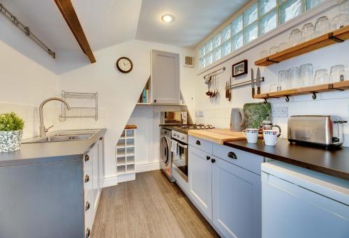 a large kitchen with white cabinets and a sink at Percy Apartments - By Week2Week in Tynemouth