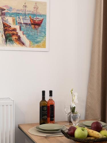 a table with two bottles of wine and fruit on it at Natalia's Lovely House in Artemida