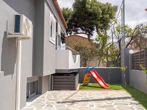 a small backyard with a slide and a playground at Natalia's Lovely House in Artemida