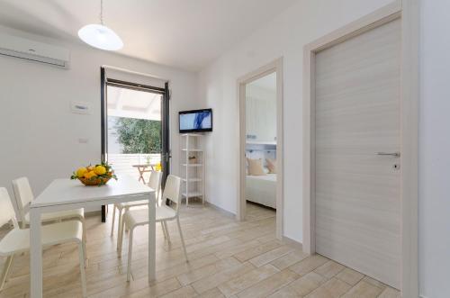 a kitchen and dining room with a table and a door at Le Case di Chri in Mattinata