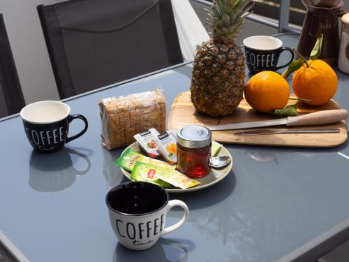 a table with two cups of coffee and a pineapple at Natalia's Lovely House in Artemida