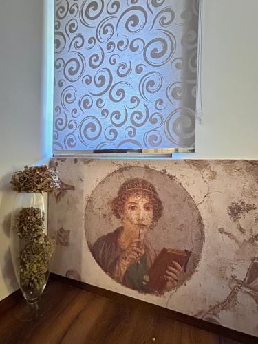 a painting of a man reading a book next to a vase at Relais Villa Alma in Castion Veronese