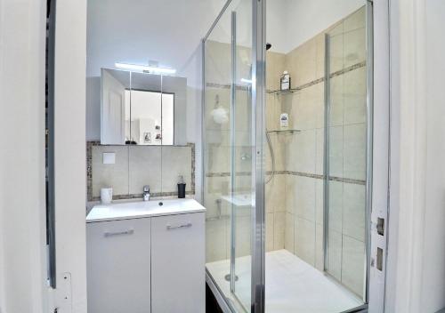 une salle de bain blanche avec une douche et un lavabo dans l'établissement Central, fully equipped, enjoy!, à La Ciotat