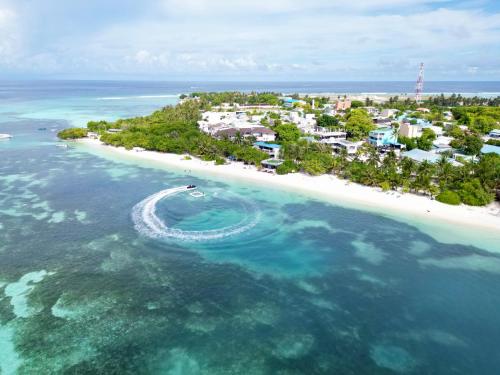 an island in the ocean with a boat in the water at FUNPLACE BEACH in Himmafushi