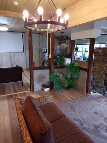 a living room with a brown couch and a projection screen at itoshima 個性的な日本家屋 in Itoshima