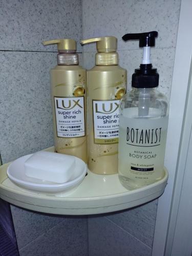 a shelf with three bottles of hair products on it at itoshima 個性的な日本家屋 in Itoshima
